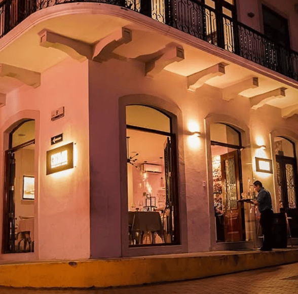 Exterior of Casco Mar restaurant at night, warmly lit on a historic corner in Casco Viejo